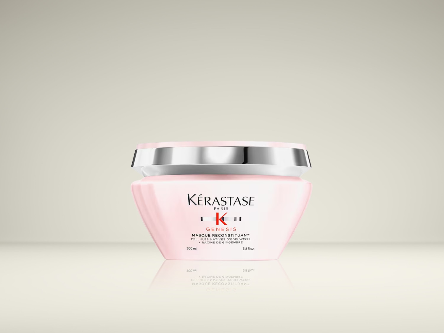 Kérastase Genesis Masque Reconstituan is een roze haarmasker in een potje met een zilverkleurige deksel, verrijkt met edelweiss stamcellen en gemberwortel, speciaal voor verzwakt haar.