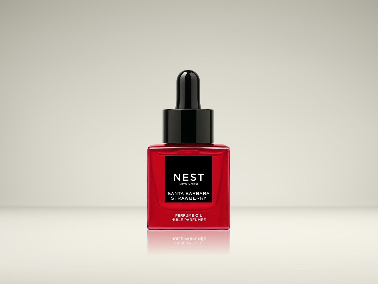 Een vierkant, rood flesje 'NEST New York Santa Barbara Strawberry Perfume Oil' met een zwarte dop en pipet.