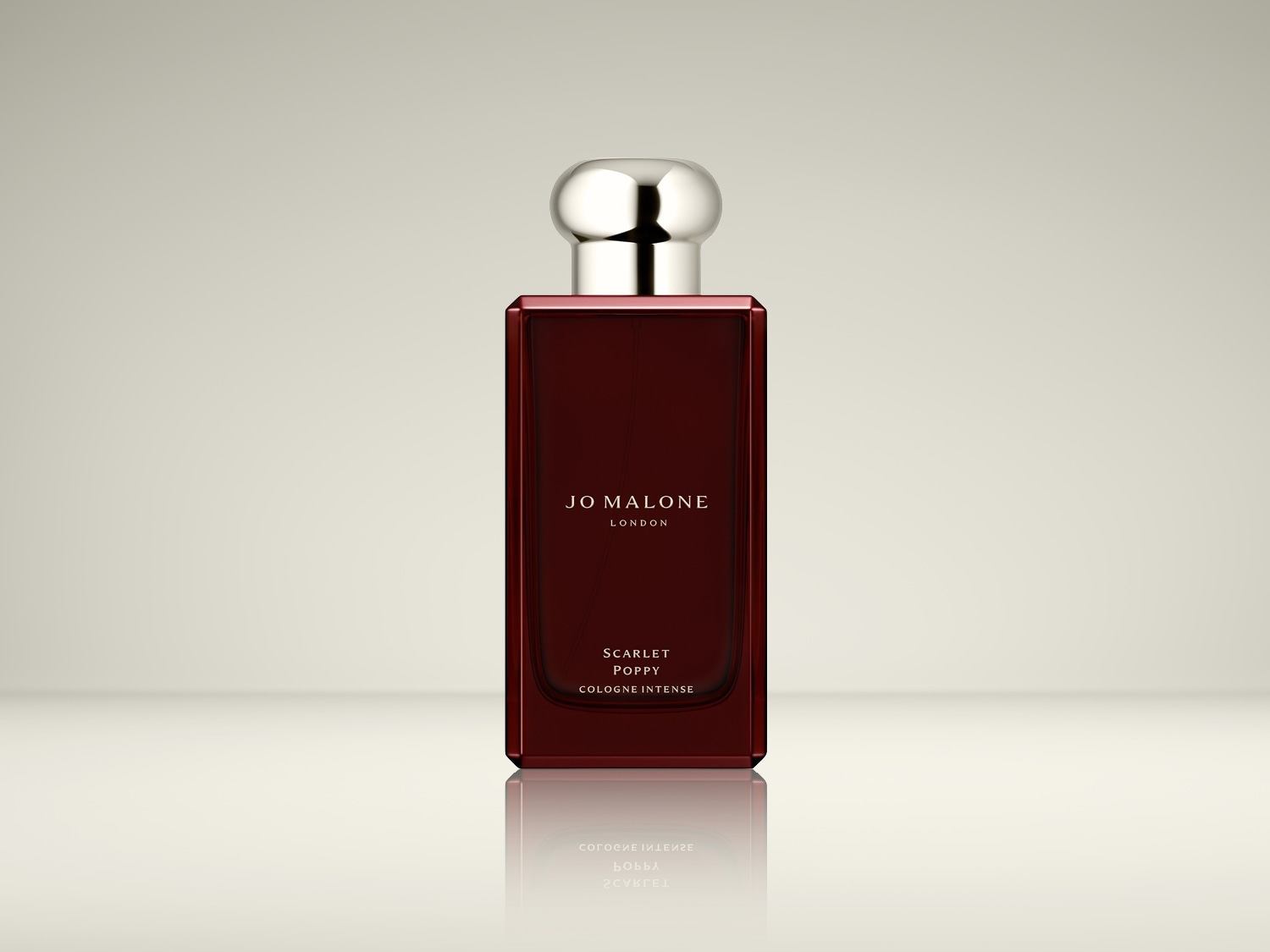 Een rechthoekige, bordeauxrode parfumfles van Jo Malone London, genaamd Scarlet Poppy Cologne Intense, met een zilveren dop.