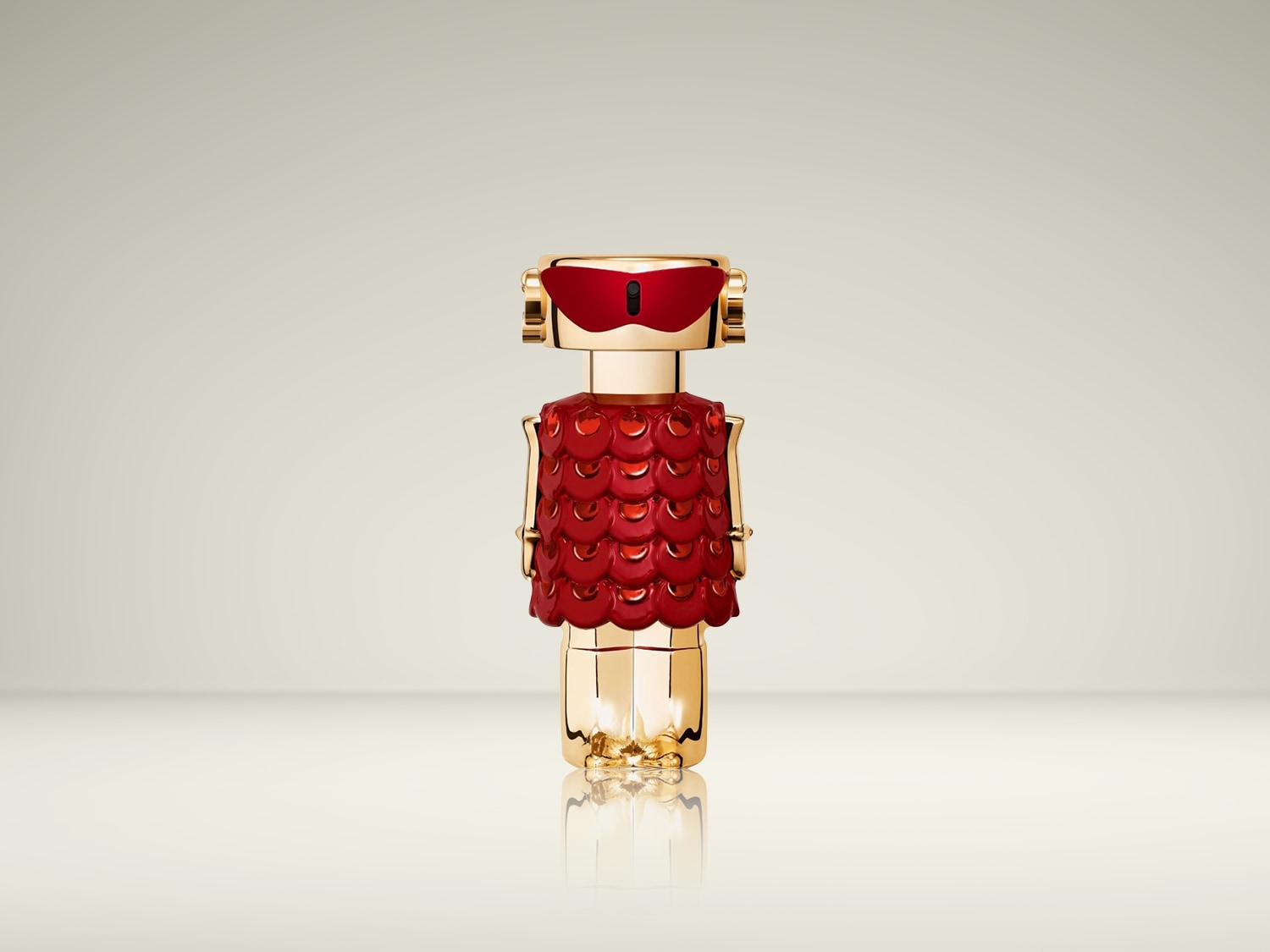 Gouden parfumflesje in de vorm van een robot met een rood schildvormig vest en een rode bril.