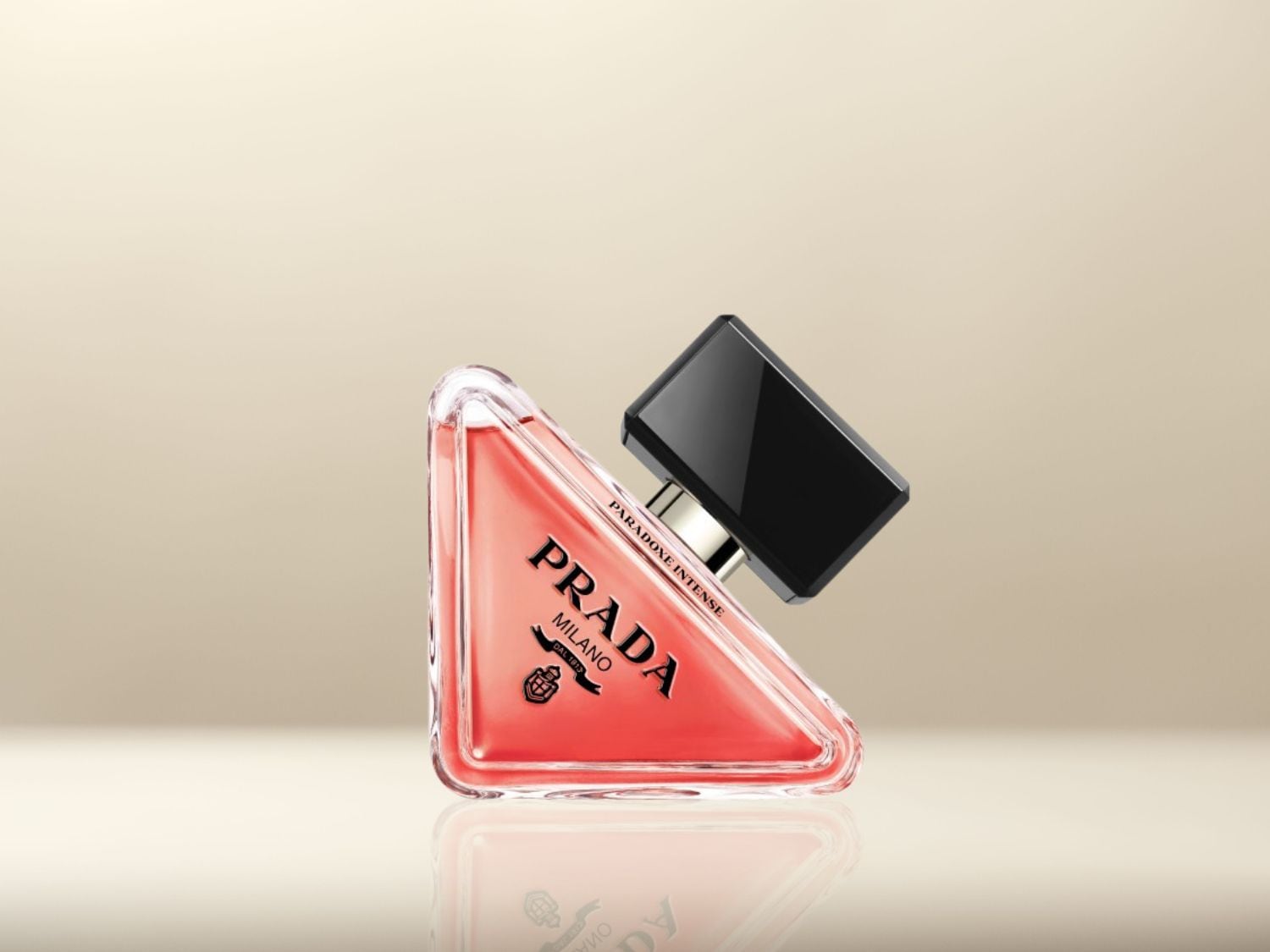 Découvrez Paradoxe Intense de Prada, un parfum captivant dans un flacon triangulaire rose corail surmonté d'un bouchon noir brillant.