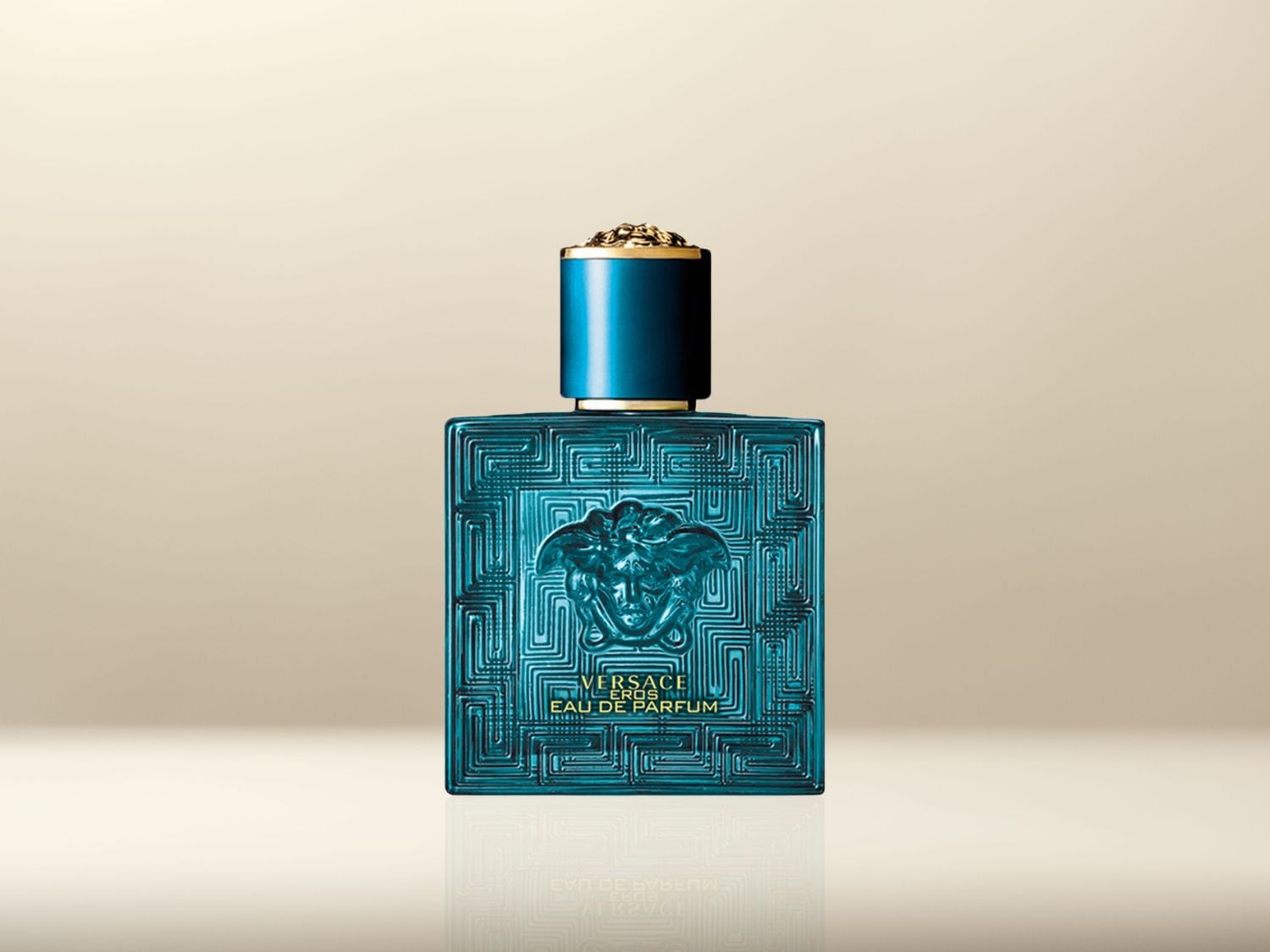 Le flacon turquoise d'Eau de Parfum Versace Eros présente un motif géométrique en relief et le logo de la marque.