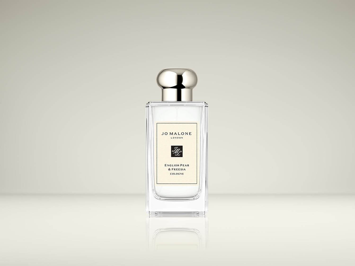 Le parfum Jo Malone London English Pear & Freesia Cologne est présenté dans un flacon en verre transparent avec un bouchon argenté, reflétant son élégance intemporelle.