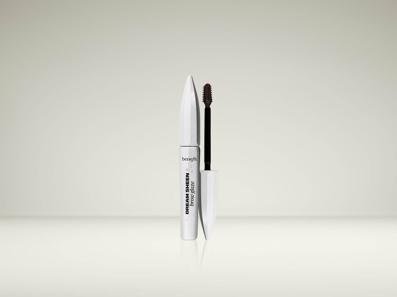 Le mascara à sourcils Benefit Dream Sheen Brow Glaze est présenté ouvert, avec sa brosse applicatrice marron foncé visible, à côté de son tube blanc élégant.