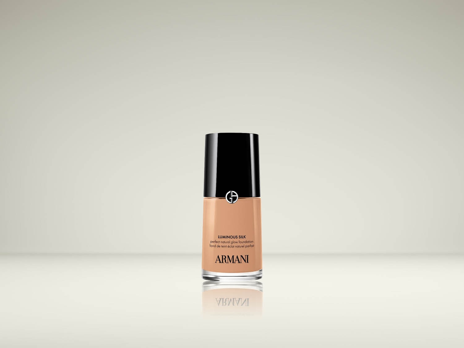 Le fond de teint Luminous Silk de Giorgio Armani, dans un flacon en verre transparent avec un bouchon noir, offre un éclat naturel parfait.
