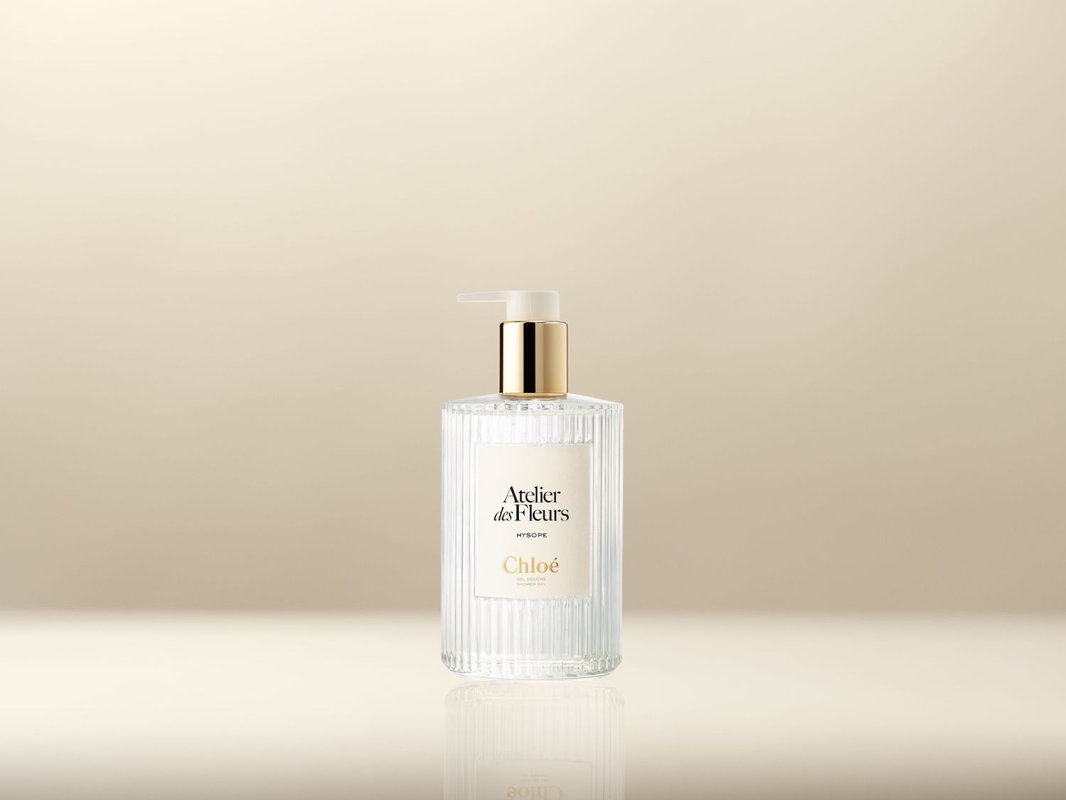 Découvrez le gel lavant pour les mains Chloé Atelier des Fleurs Hyssope, présenté dans un flacon en verre transparent avec une pompe dorée, pour une expérience de nettoyage luxueuse et parfumée.