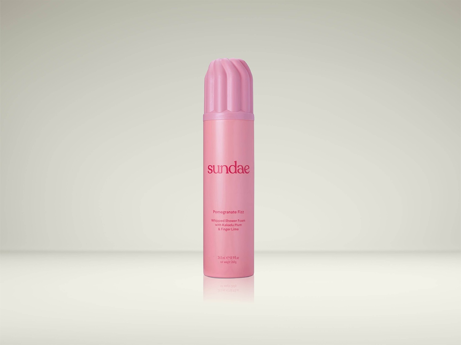 Voici un aérosol rose de mousse de douche fouettée Sundae Pomegranate Fizz, infusée de prune de Kakadu et de citron vert.