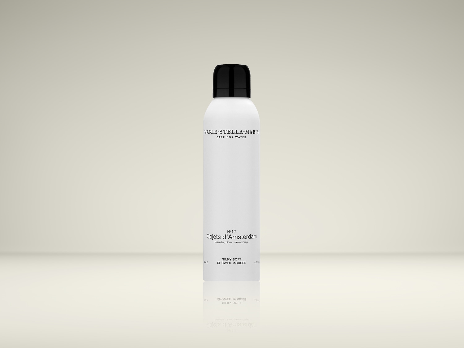 Voici un flacon blanc de mousse de douche soyeuse Marie-Stella-Maris Objets d'Amsterdam N°12, avec des notes de thé vert, d'agrumes et de sauge, coiffé d'un bouchon noir.