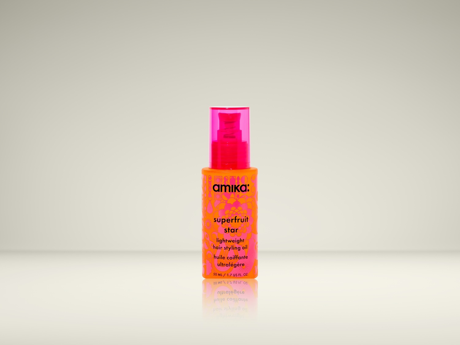 Huile coiffante légère Amika Superfruit Star dans un flacon orange vif avec des accents floraux roses et un bouchon rose.