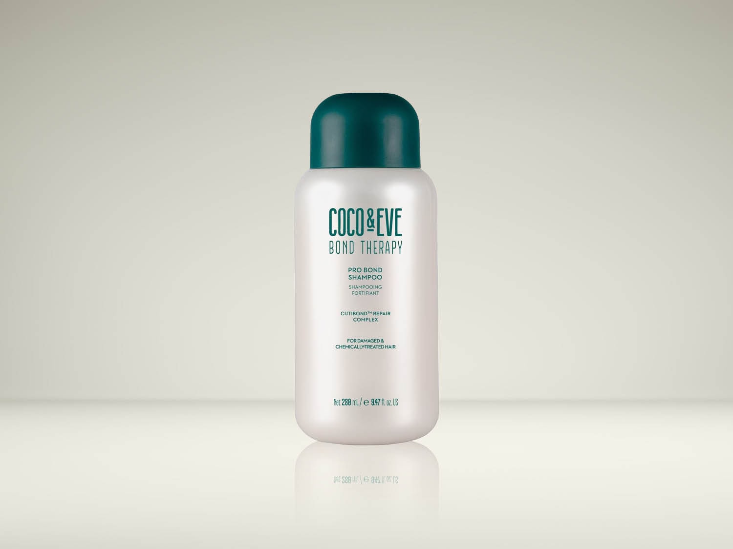 Le shampooing Coco & Eve Bond Therapy Pro Bond, présenté dans une bouteille blanche avec un bouchon vert foncé, est formulé pour les cheveux abîmés et traités chimiquement, offrant un complexe réparateur Cutibond™.