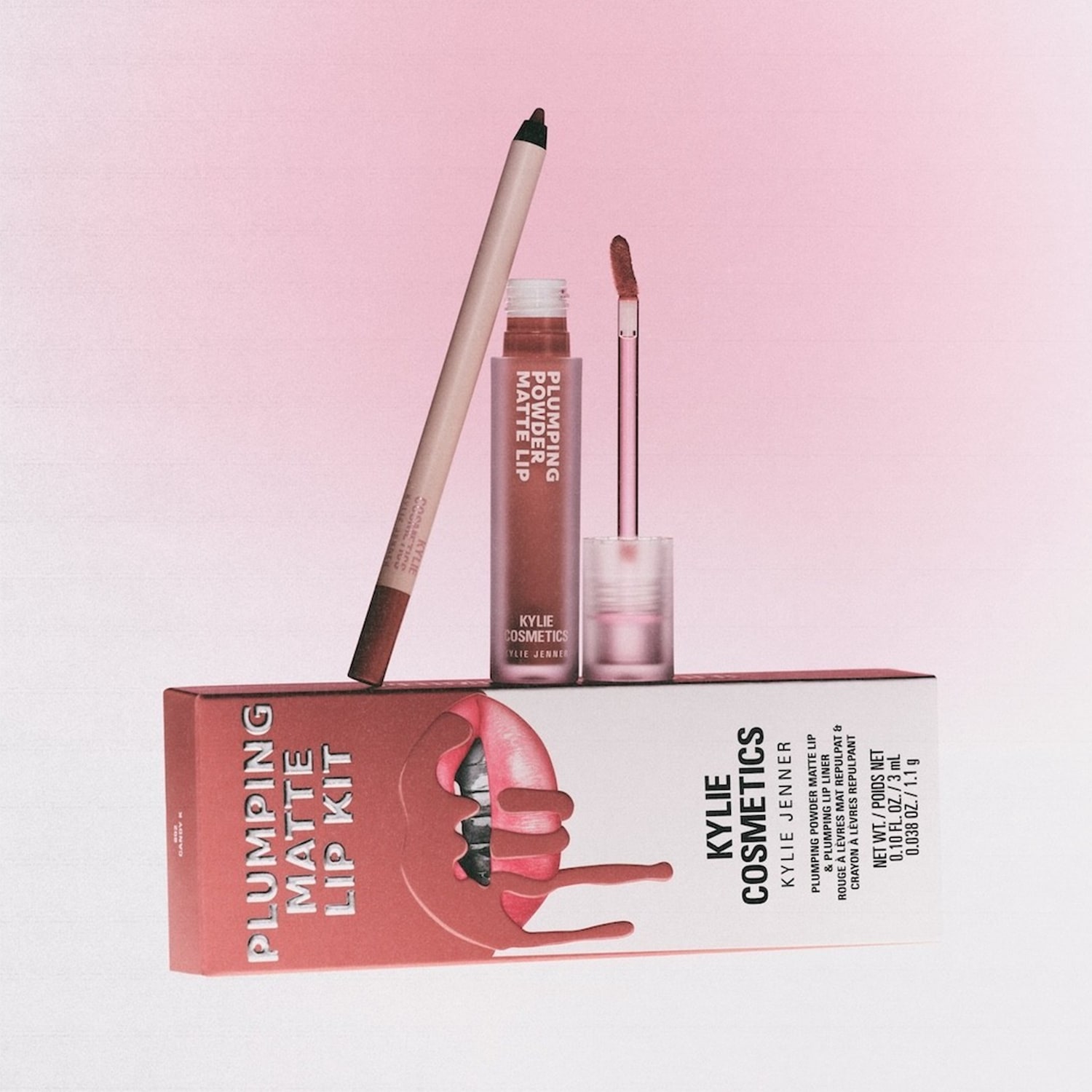 De Kylie Cosmetics Plumping Matte Lip Kit in de kleur Candy K, bestaande uit een lipliner en een plumping matte lip, wordt gepresenteerd op een roze achtergrond.