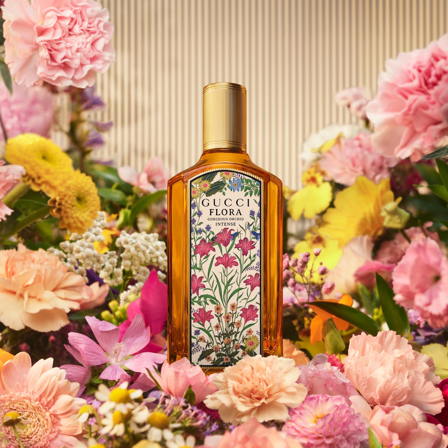 De Gucci Flora Gorgeous Orchid Intense parfumfles, omringd door een weelderige bloemenpracht van roze, gele en oranje bloemen, staat centraal op een gestreepte achtergrond.