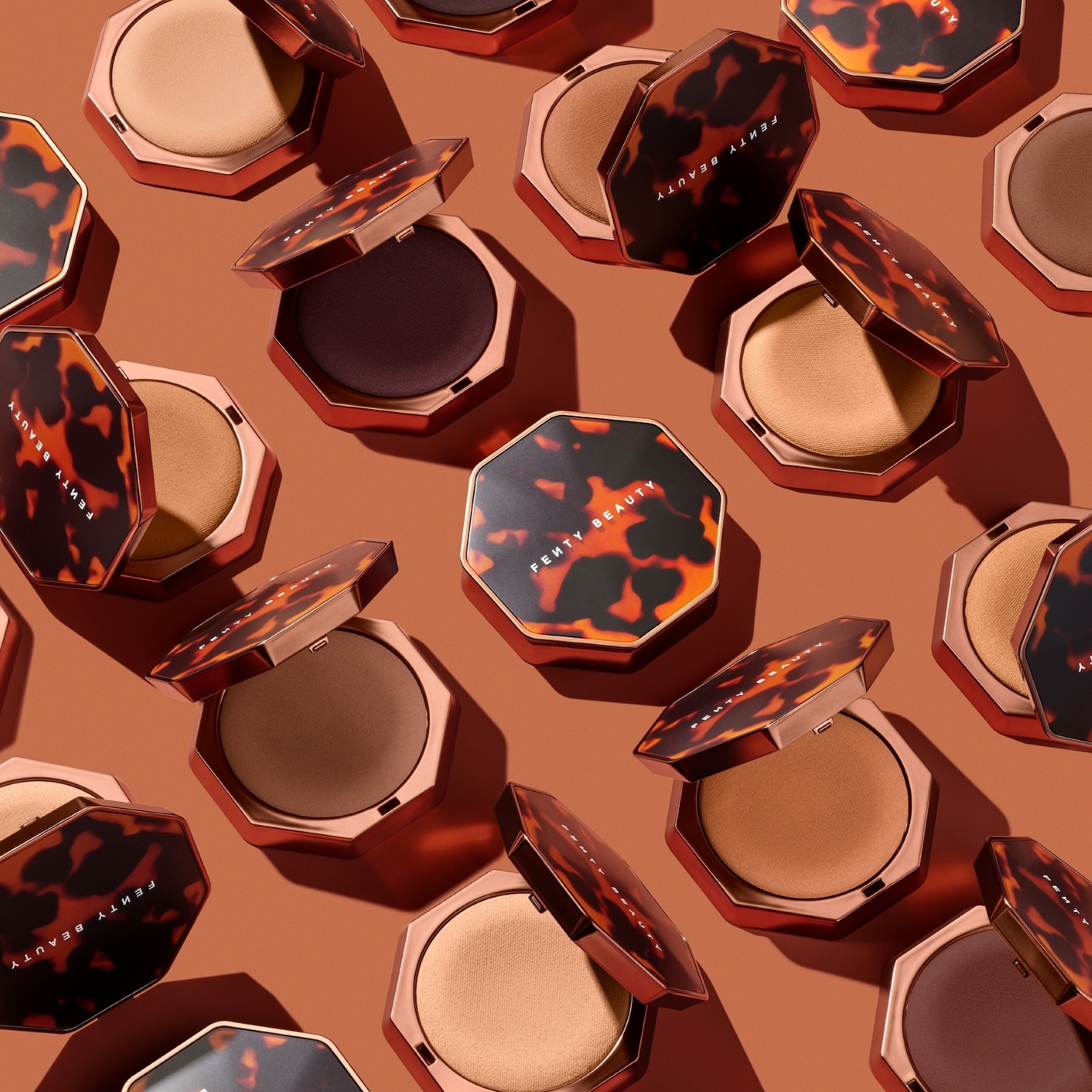 Een close-up van Fenty Beauty compact poeders in verschillende tinten, elk met een schildpadpatroon op de verpakking, open om de poeder binnenin te laten zien.