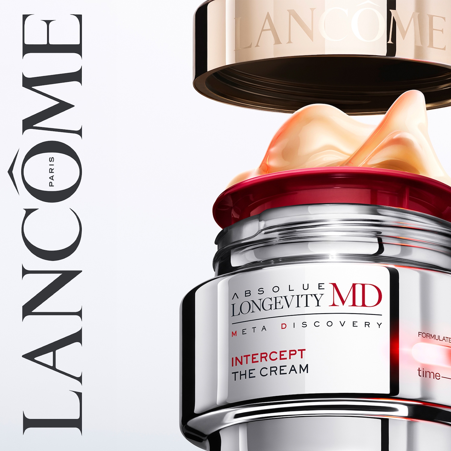 Lancôme Absolue Longevity MD Intercept The Cream in een zilveren pot met een gouden deksel, met een rijke, perzikkleurige crème die eruit puilt.