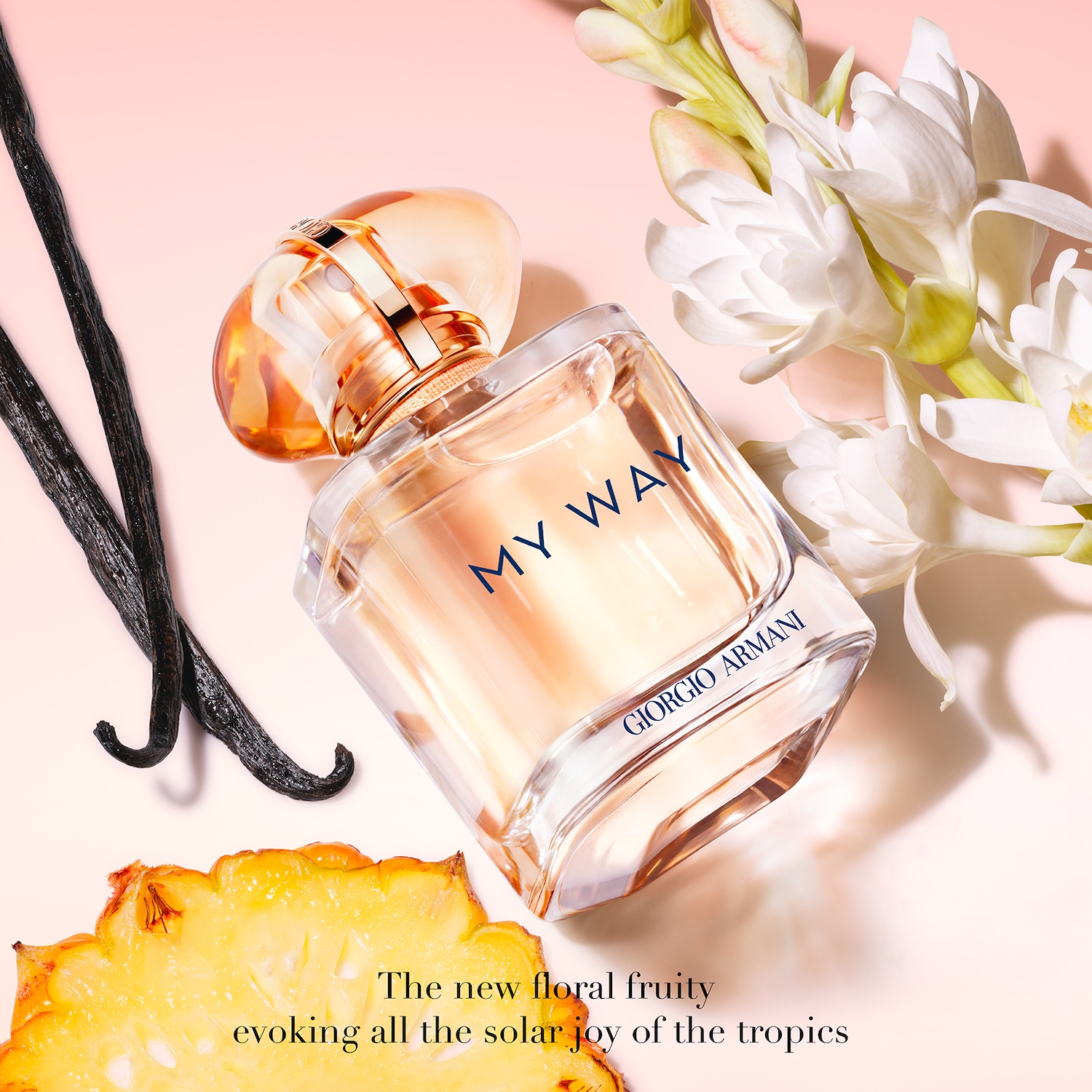 De Giorgio Armani My Way parfumfles, met een oranje dop en een heldere basis, ligt op een lichtroze achtergrond, omringd door vanillestokjes, een ananasschijf en witte bloemen, met de tekst "The new floral fruity evoking all the solar joy of the tropics".