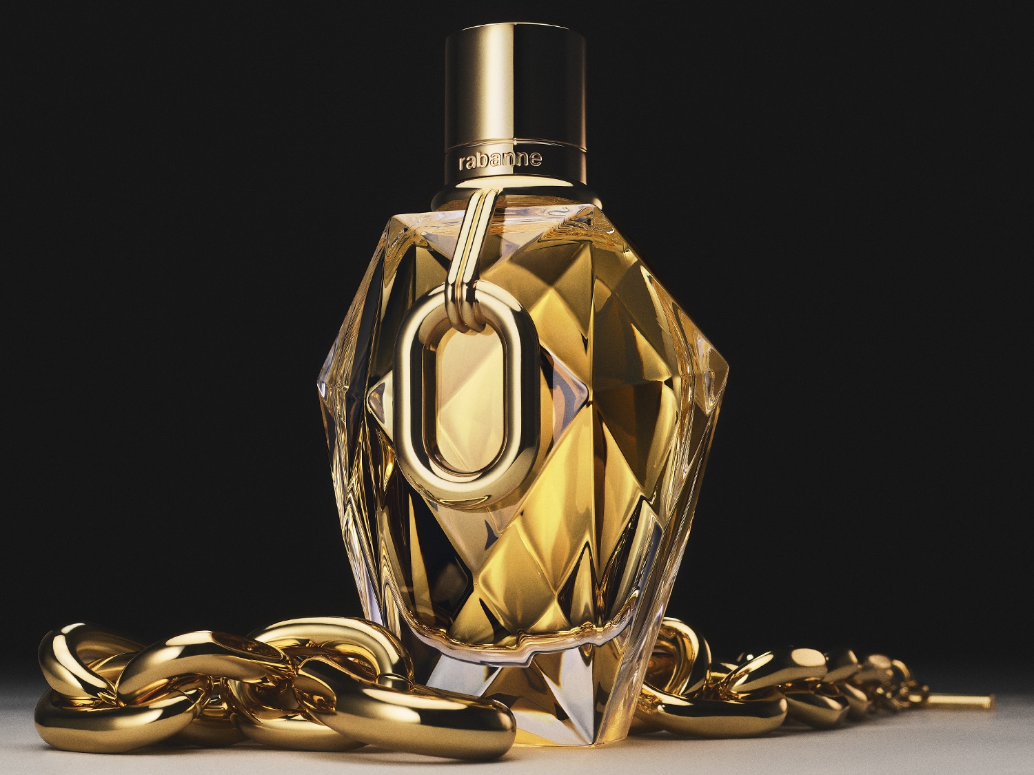 Découvrez le parfum Rabanne dans un flacon doré aux multiples facettes, orné d'une chaîne dorée.