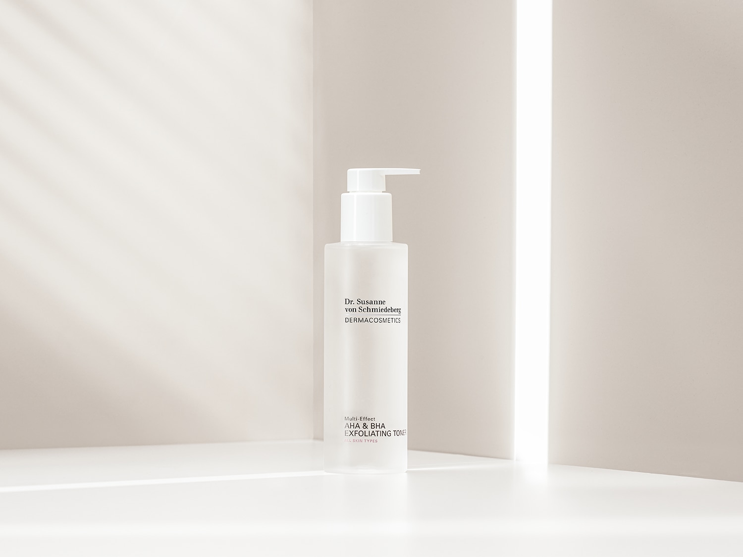 Een witte fles Dr. Susanne von Schmiedeberg DERMACOSMETICS Multi-Effect AHA & BHA Exfoliating Toner voor alle huidtypes staat in een zachte, lichte omgeving.