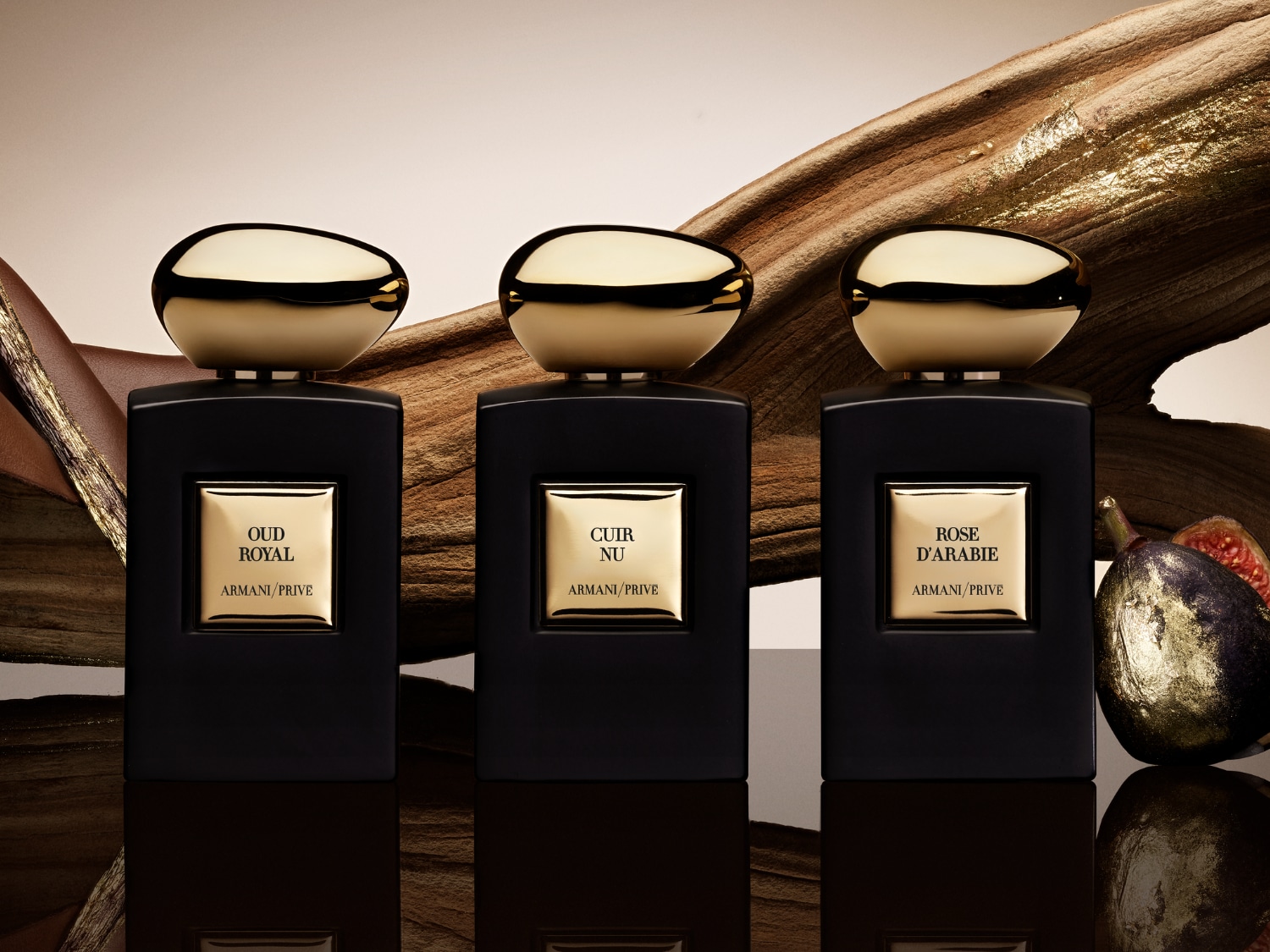 Három Armani/Privé parfümös üveg látható, arany kupakkal és fekete üveggel, Oud Royal, Cuir Nu és Rose D'arabie felirattal.