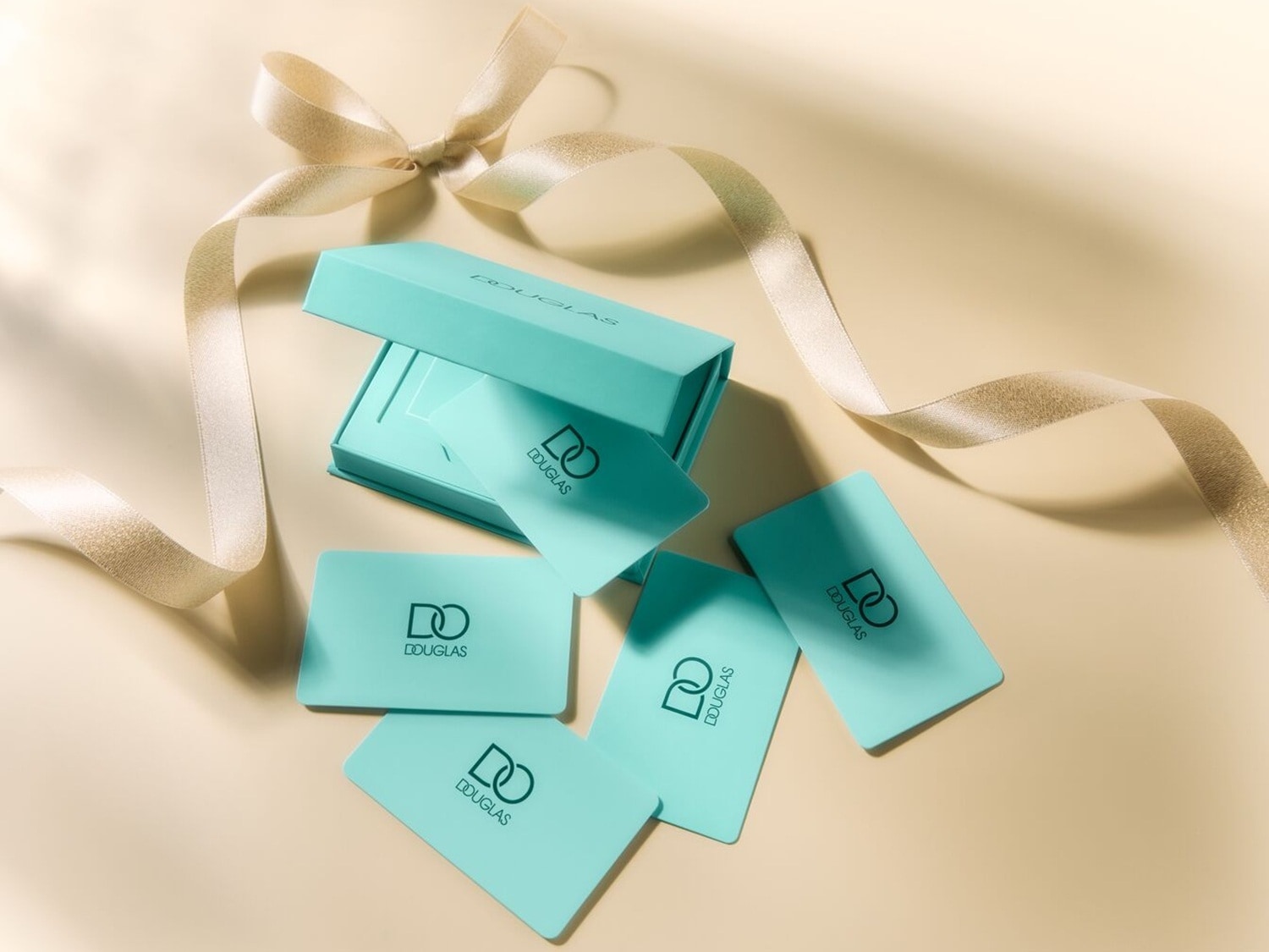 Ein hellblaues Douglas-Geschenkkarten-Set mit Schleife, ideal zum Verschenken von Beauty- und Duftprodukten.