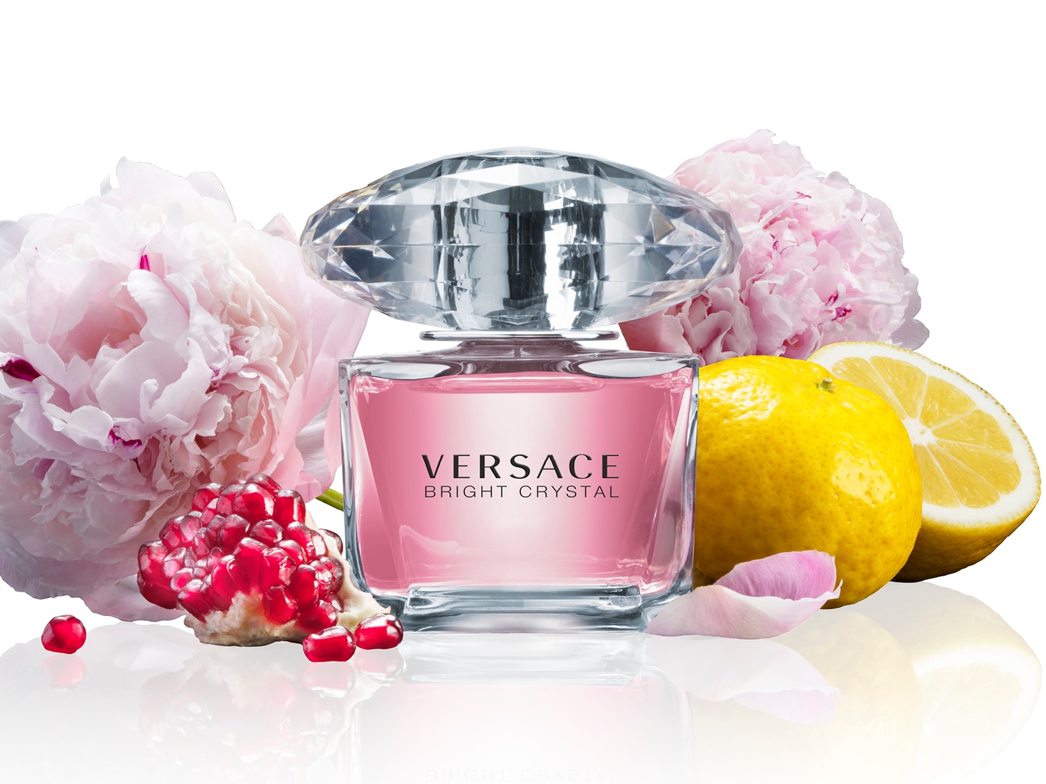 Découvrez le parfum Versace Bright Crystal, un floral fruité dans un flacon rose élégant avec un bouchon en forme de diamant, entouré de pivoines, de grenade et de citron.