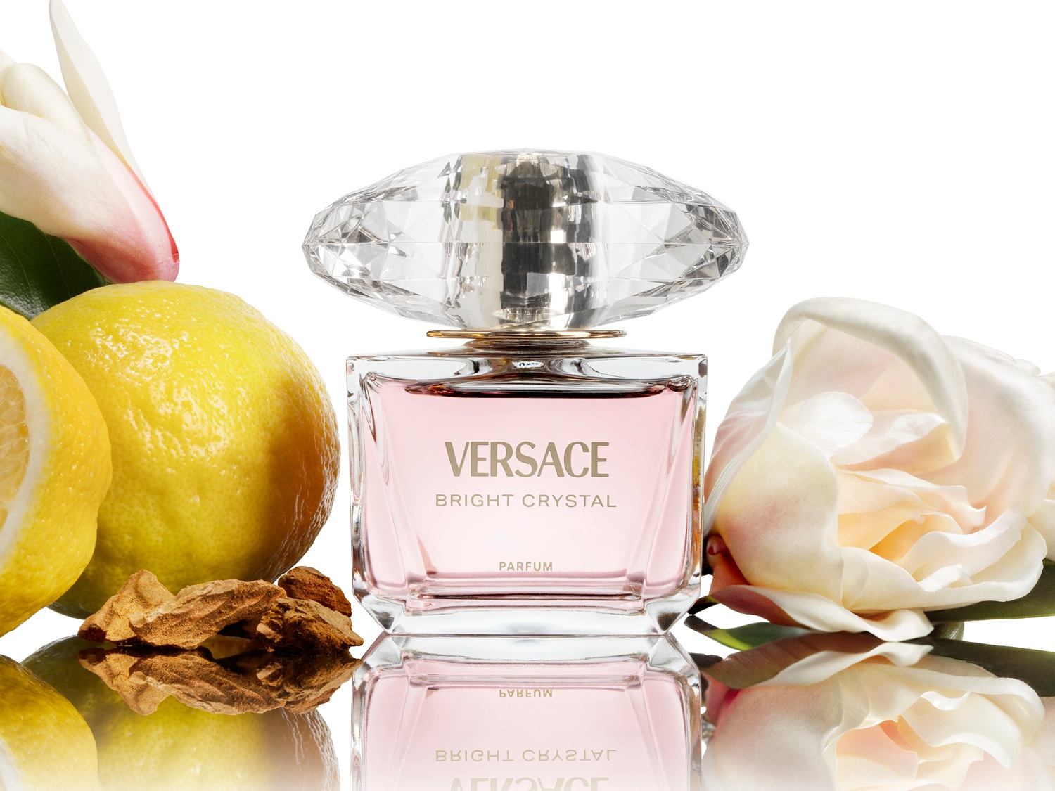 Découvrez le parfum Versace Bright Crystal, un parfum délicat dans un flacon rose élégant avec un bouchon en forme de diamant, entouré de citron et de fleurs blanches.