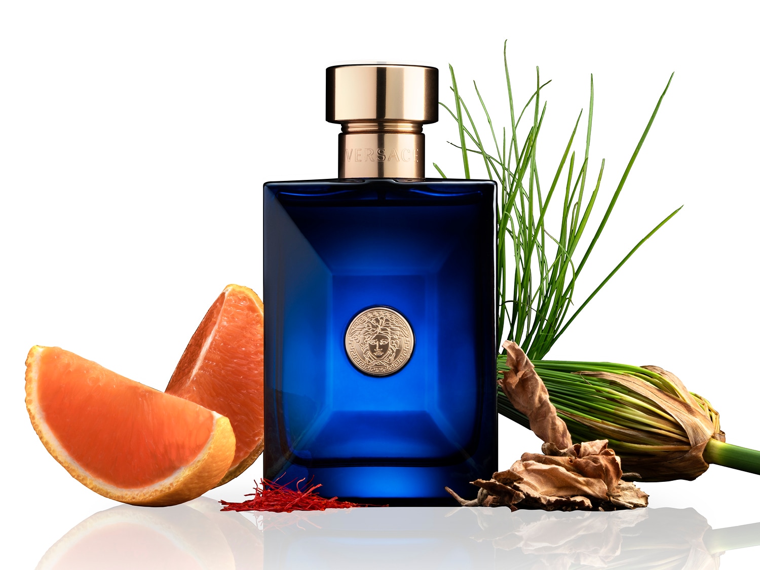 Le parfum Versace bleu foncé est mis en valeur avec des tranches d'orange, des herbes vertes et des épices, offrant une expérience olfactive riche et complexe.