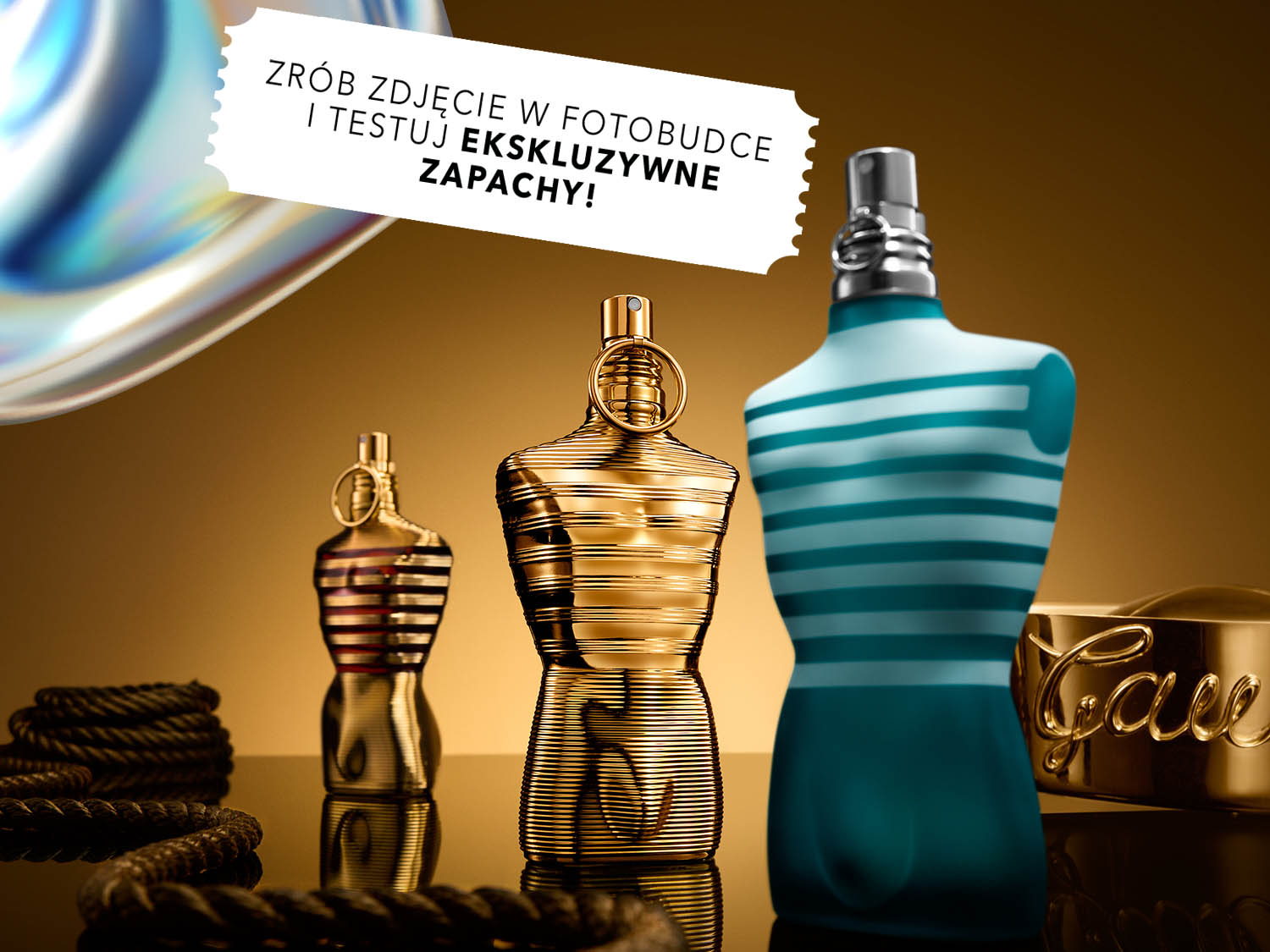 Złota butelka perfum w kształcie męskiego torsu z napisem z tyłu na złotym tle.