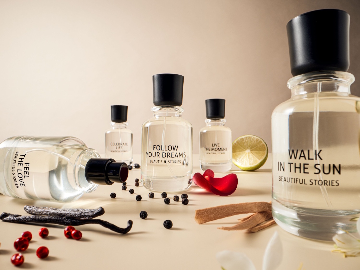Kvepalų kolekcija „Beautiful Stories“ su užrašais „Feel the Love“, „Celebrate Life“, „Follow Your Dreams“, „Live the Moment“ ir „Walk in the Sun“ ant skaidrių buteliukų su juodais kamšteliais, papuoštais gėlėmis, uogomis ir prieskoniais.