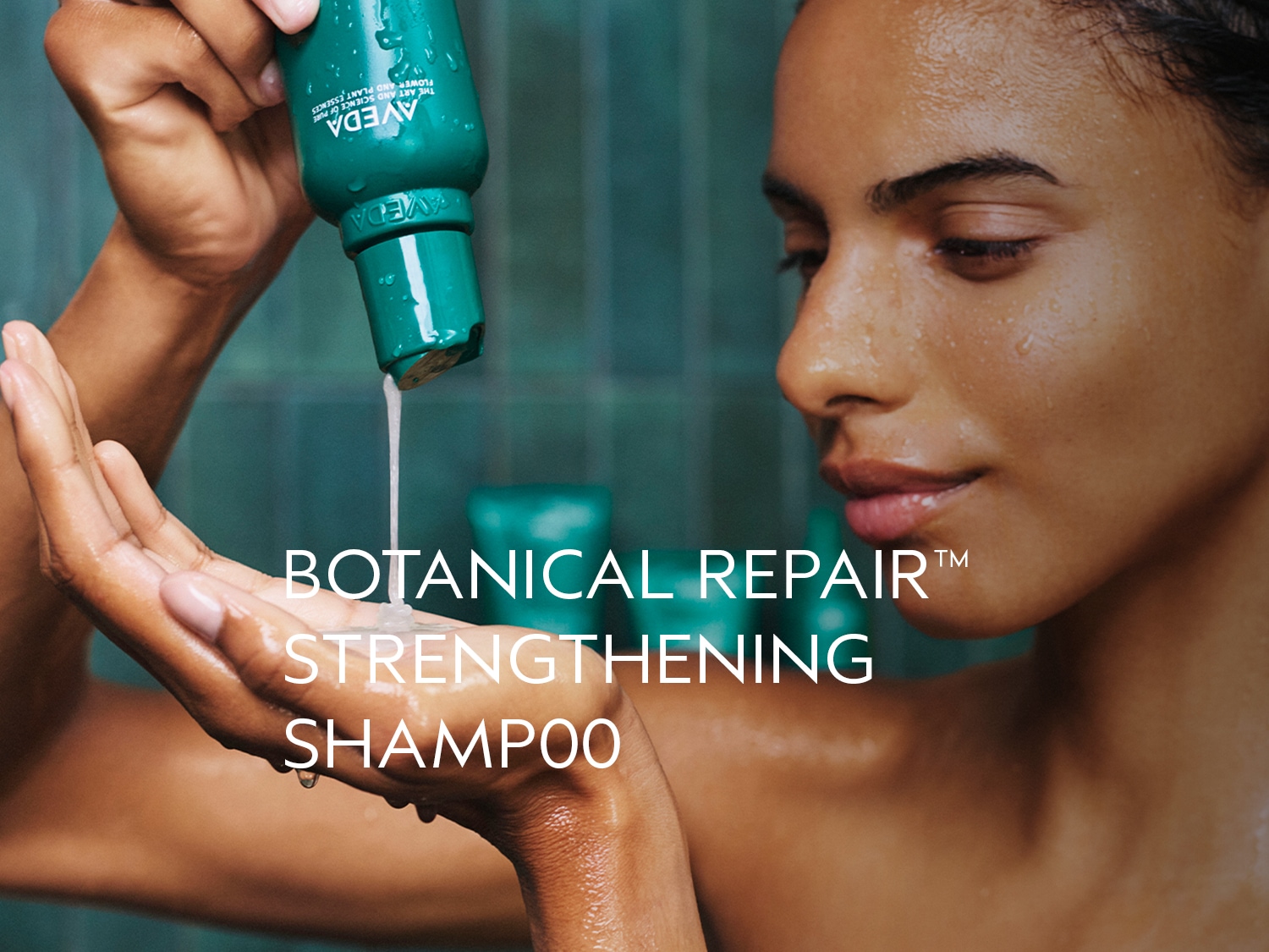 Een vrouw giet Aveda Botanical Repair Strengthening Shampoo uit een groene fles in haar hand, de shampoo is wit en crèmig.