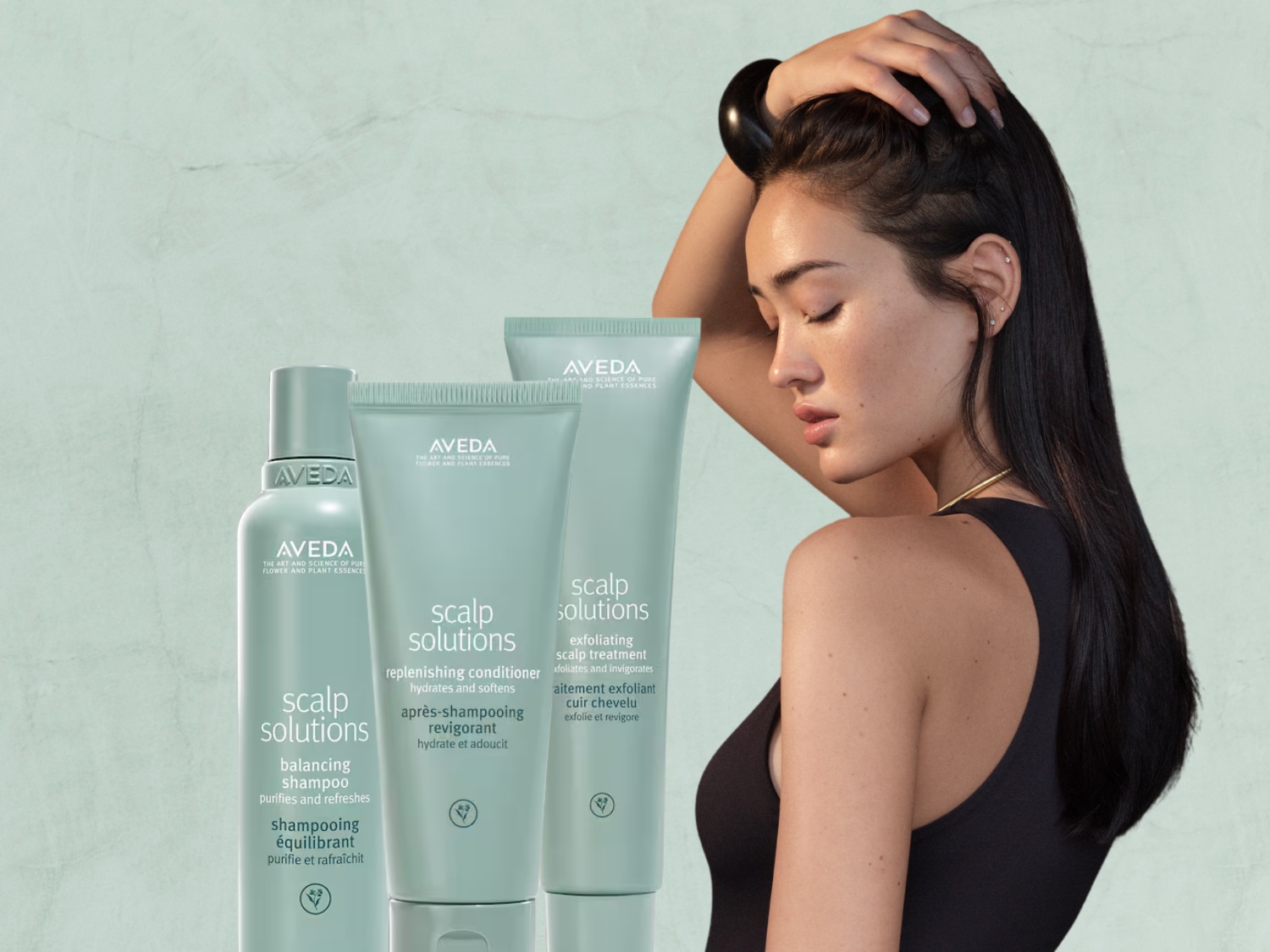 Aveda Scalp Solutions-lijn, met een balancerende shampoo, een revitaliserende conditioner en een exfoliërende hoofdhuidbehandeling in lichtgroene verpakkingen.
