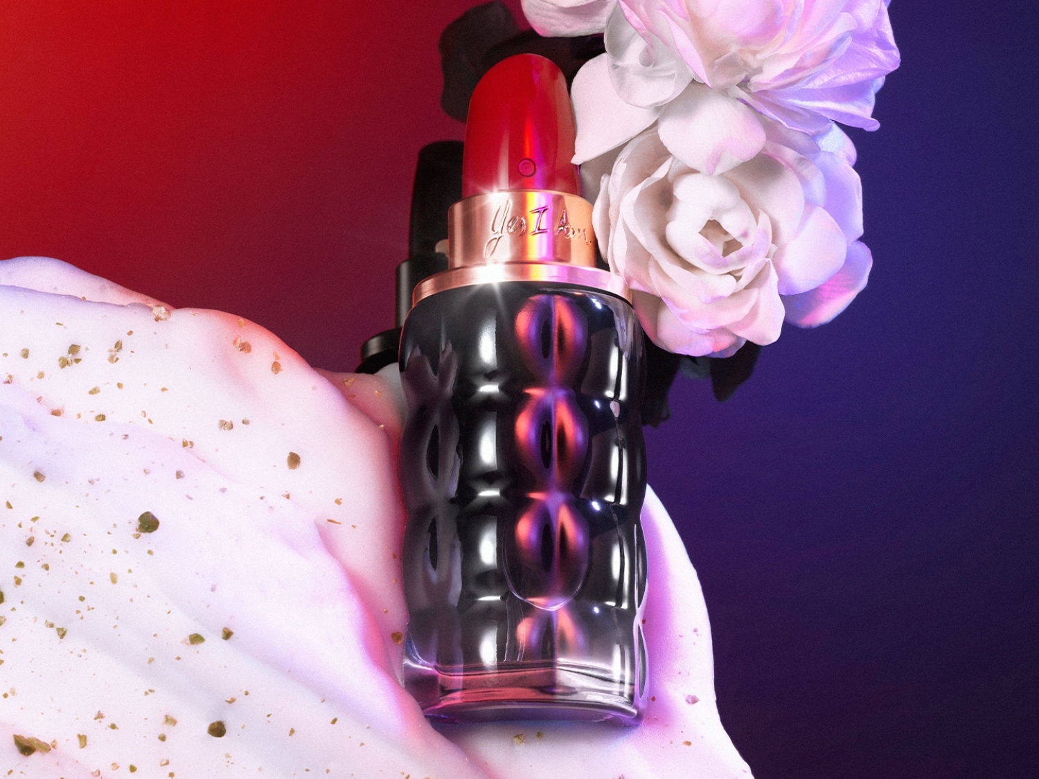 Le parfum Yes I Am de Cacharel, présenté dans un flacon en forme de rouge à lèvres rouge et noir, est mis en valeur par des fleurs blanches et une mousse dorée, le tout sur un fond rouge et violet.