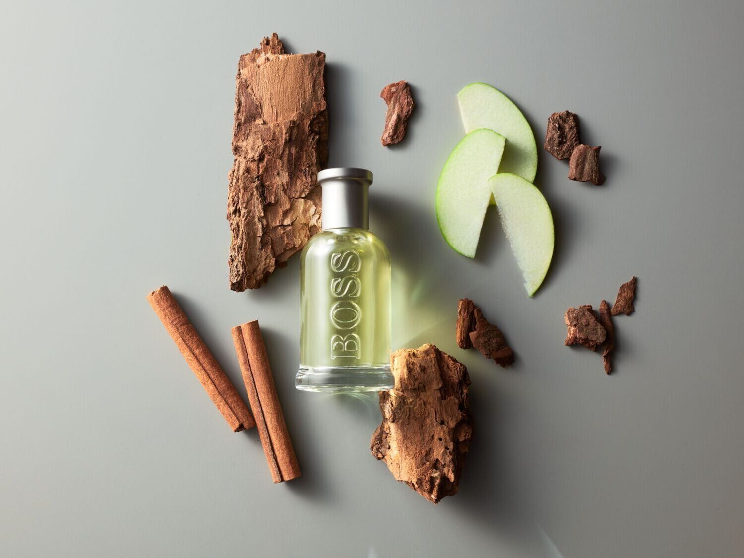 BOSS kvepalų buteliukas su obuolių griežinėliais, cinamono lazdelėmis ir medžio žieve sukuria natūralų ir gaivų kvapą.