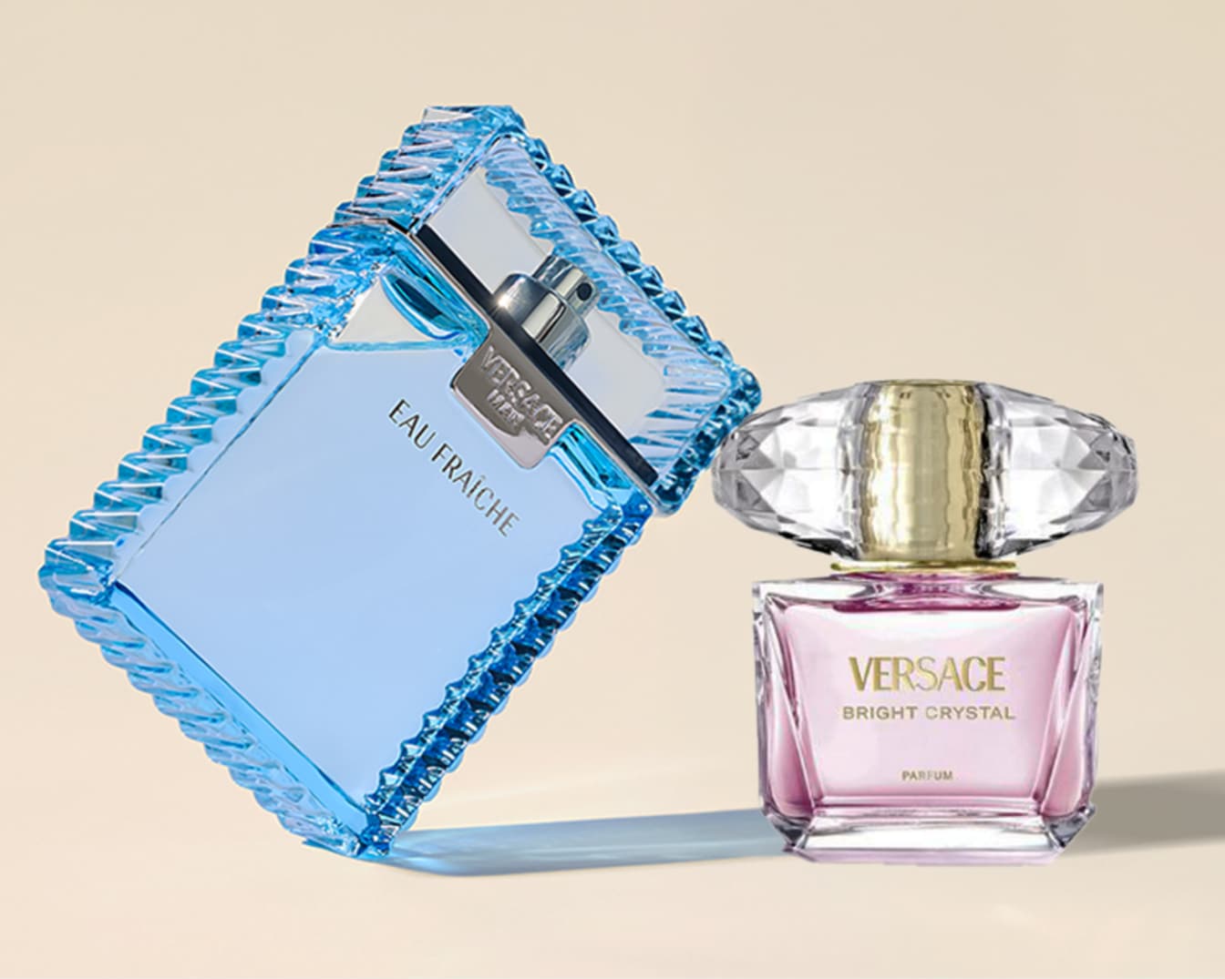 Du Versace kvepalų buteliukai: vienas vyriškas, mėlynas Eau Fraiche, o kitas moteriškas, rožinis Bright Crystal, elegantiškai eksponuojami ant švelnaus fono.