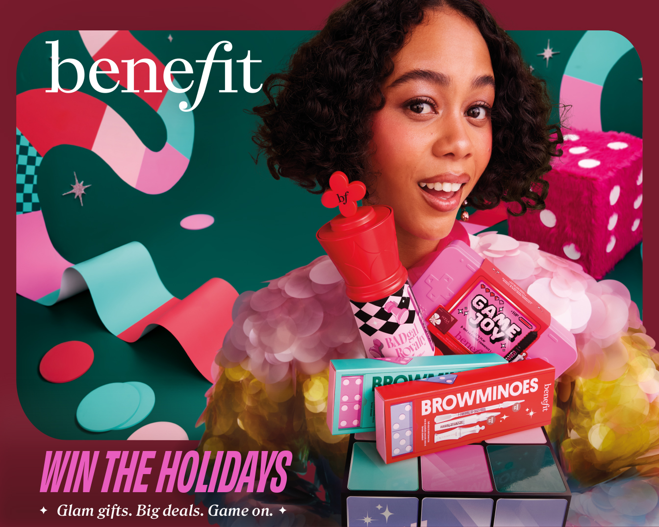 Win de feestdagen met Benefit! Glam cadeaus, geweldige deals en speelplezier. Het model toont Benefit producten zoals BADgal, Browmiones en Game Joy.