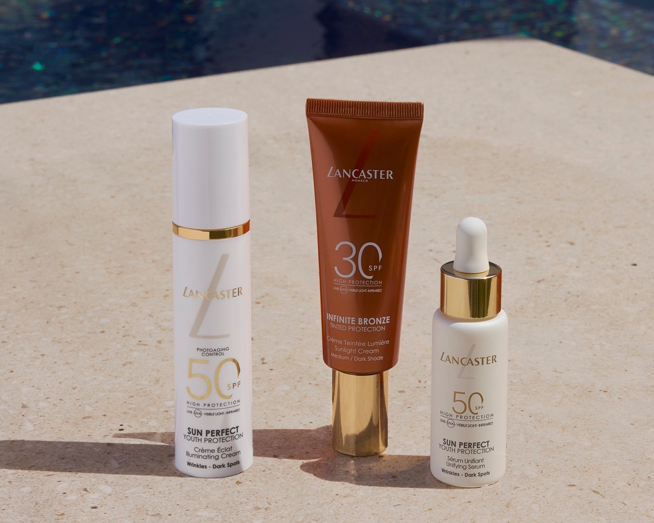 Tre prodotti Lancaster per la protezione solare: crema illuminante SPF 50, protezione solare colorata SPF 30 e siero uniformante SPF 50.