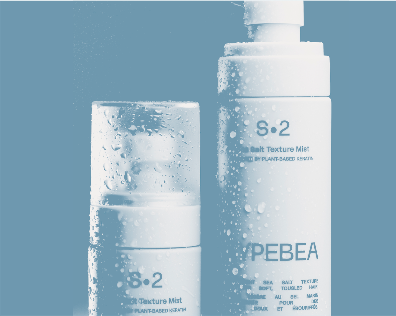 A PEBEA S.2 só textúra spray növényi alapú keratinnal, amely lágy, tengeri sóval készült a kócos hajért, fehér csomagolásban, vízcseppekkel.