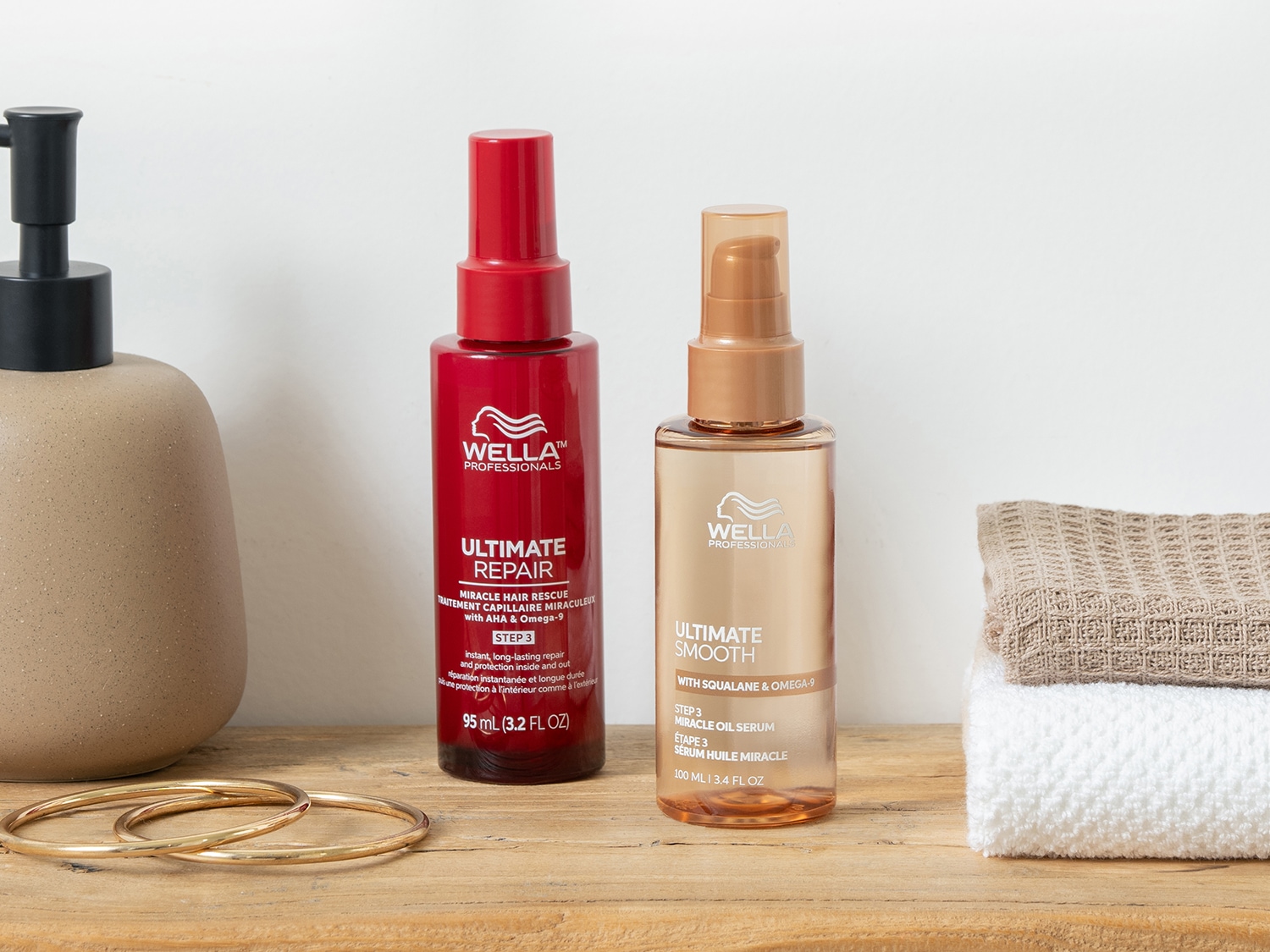 Ecco due flaconi di siero per capelli Wella Professionals: uno rosso per riparazione intensa e uno dorato per levigatezza, entrambi con formule arricchite per capelli splendenti.