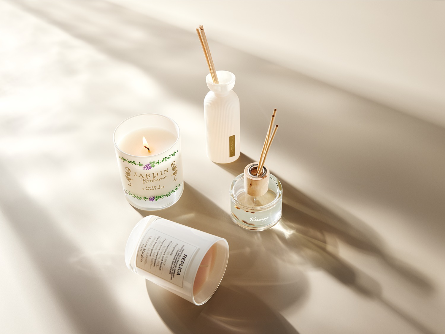 Een sfeervolle setting met geurkaarsen van Jardin Bohème en Maison Margiela, samen met een Kneipp geurverspreider, die een ontspannen en romantische sfeer creëren.