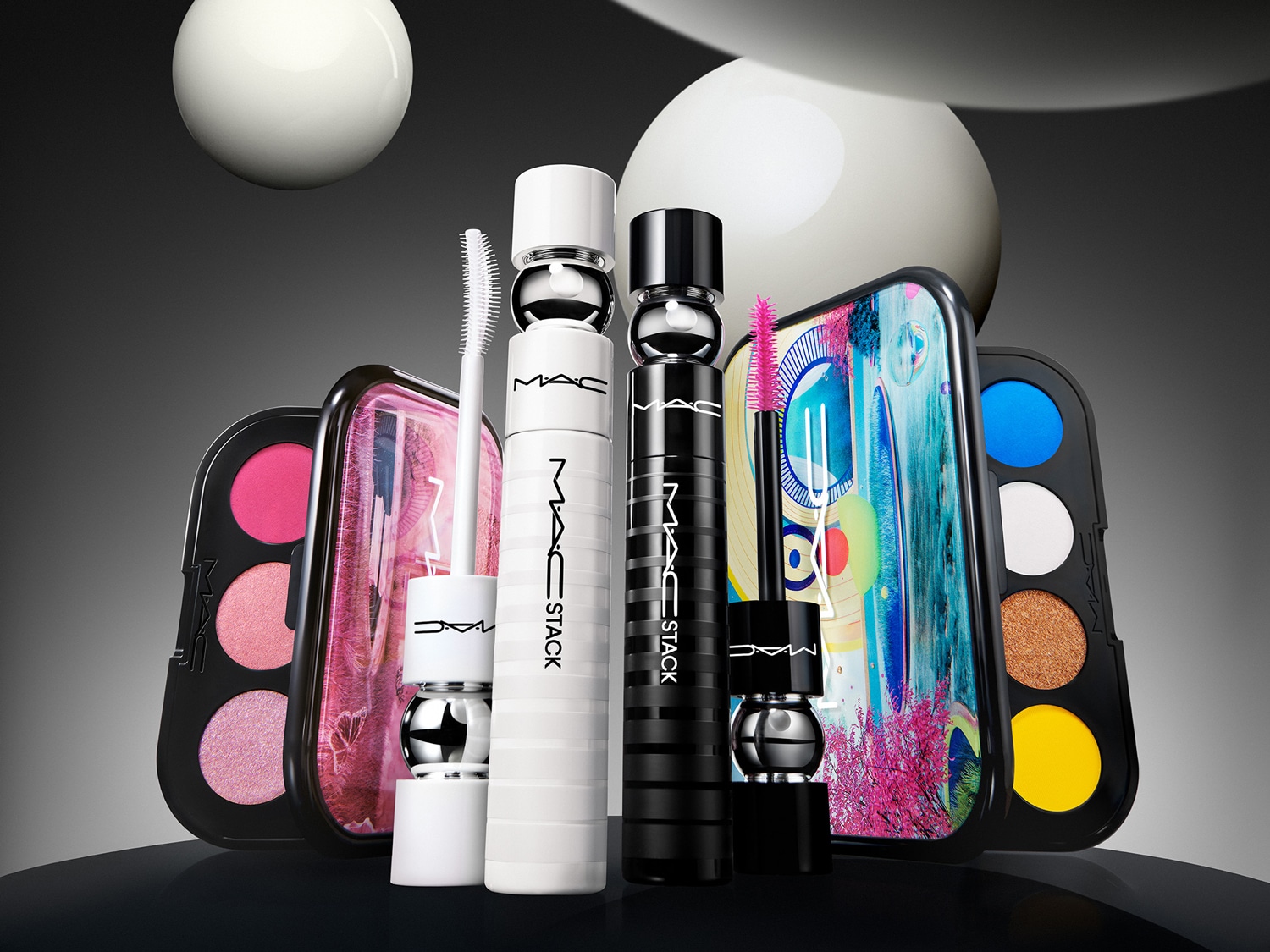 Découvrez le mascara MAC Stack en noir et blanc, présenté avec des palettes de fards à paupières aux couleurs vives, pour un look personnalisé et audacieux.