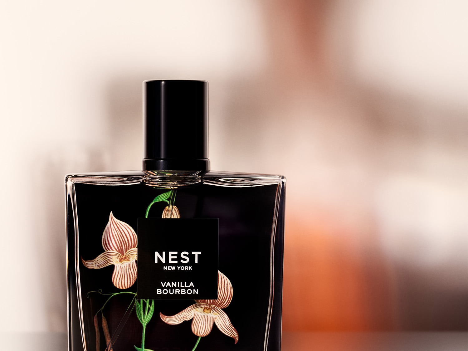 Ez a NEST New York Vanilla Bourbon parfümös üveg, fekete címkével és virágmintával, kifinomult illatot sugall.
