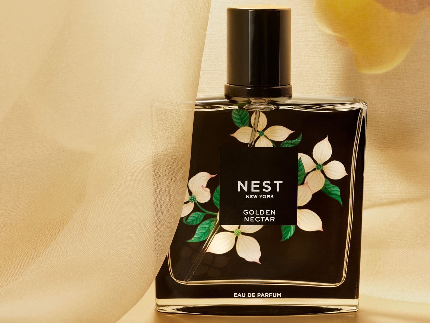 A Nest New York Golden Nectar Eau de Parfum üvegben, fekete címkével, virágmintával és arany kupakkal.