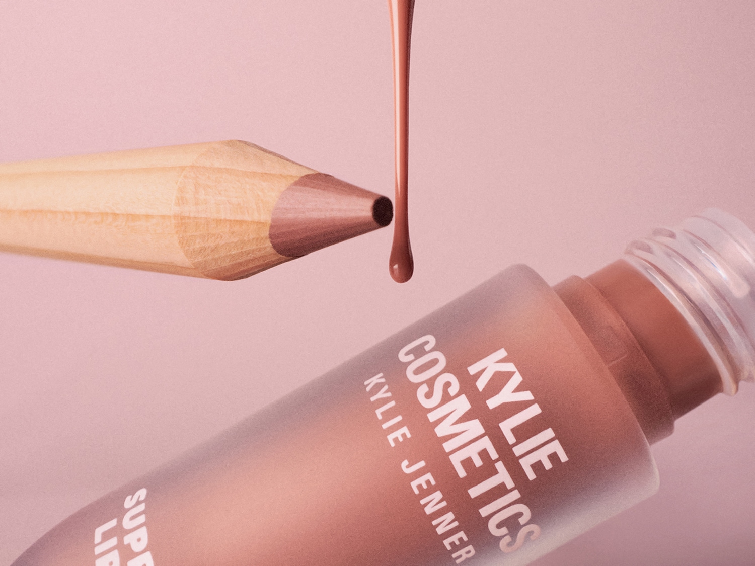 Primo piano di un viso con ombretto rosa sugli occhi e labbra lucide e rosate, per un look fresco e luminoso.