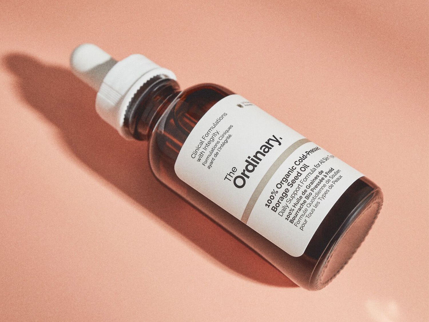 Voici l'huile de graines de bourrache 100 % biologique pressée à froid de The Ordinary, un soin quotidien pour tous les types de peau, présentée dans un flacon en verre ambré avec une pipette blanche.