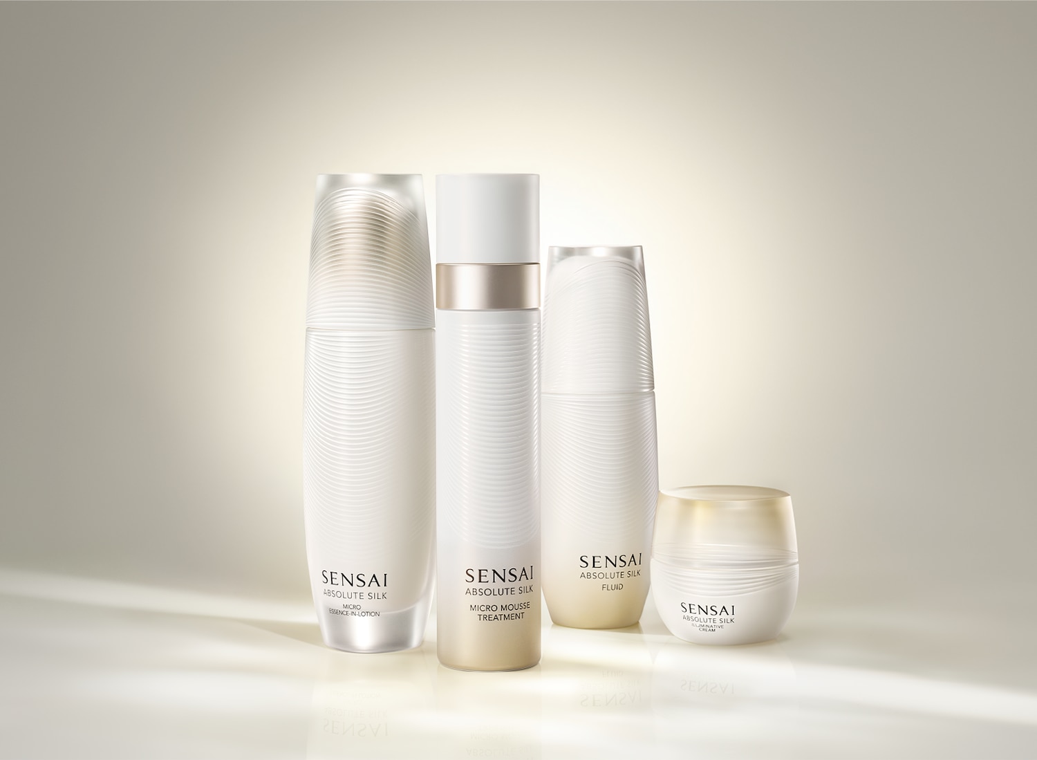 Die Sensai Absolute Silk-Kollektion umfasst vier weiße Flaschen mit Lotion, Mousse, Fluid und Creme für ein umfassendes Hautpflegeerlebnis.