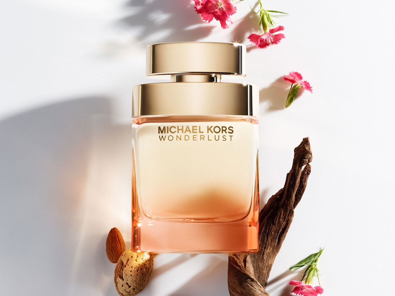 Découvrez le parfum Michael Kors Wonderlust, un flacon carré aux tons pêche et or, entouré de fleurs roses et de notes boisées, évoquant une escapade olfactive.