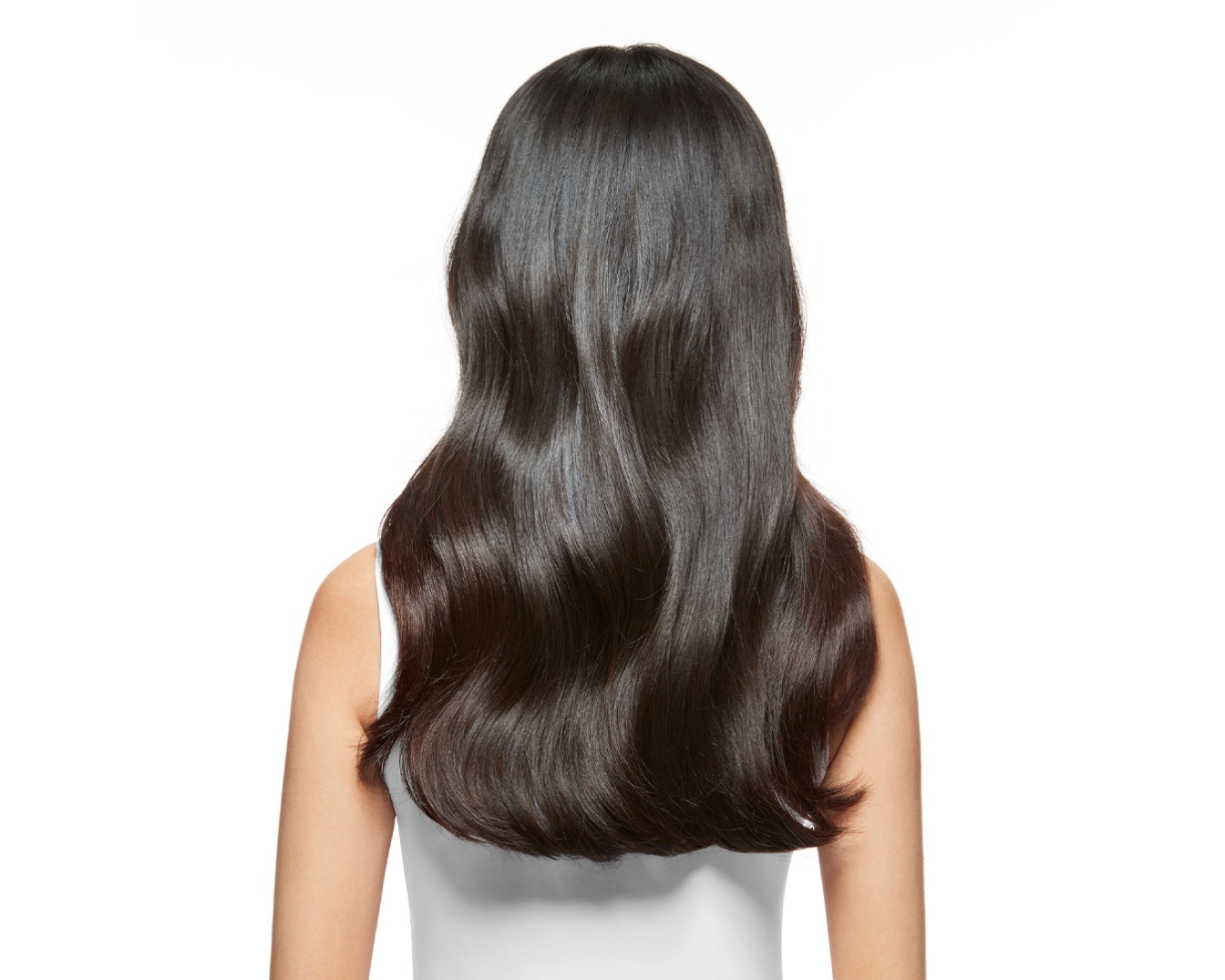 Van achteren gezien heeft de vrouw glanzend, golvend, donkerbruin haar dat tot net over haar schouders valt, tegen een witte achtergrond.