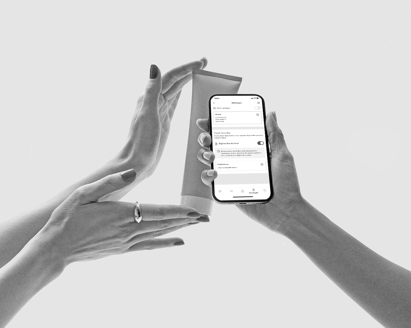 Eine Hand hält eine Tube und ein Smartphone, auf dem die Einstellungen der App angezeigt werden.