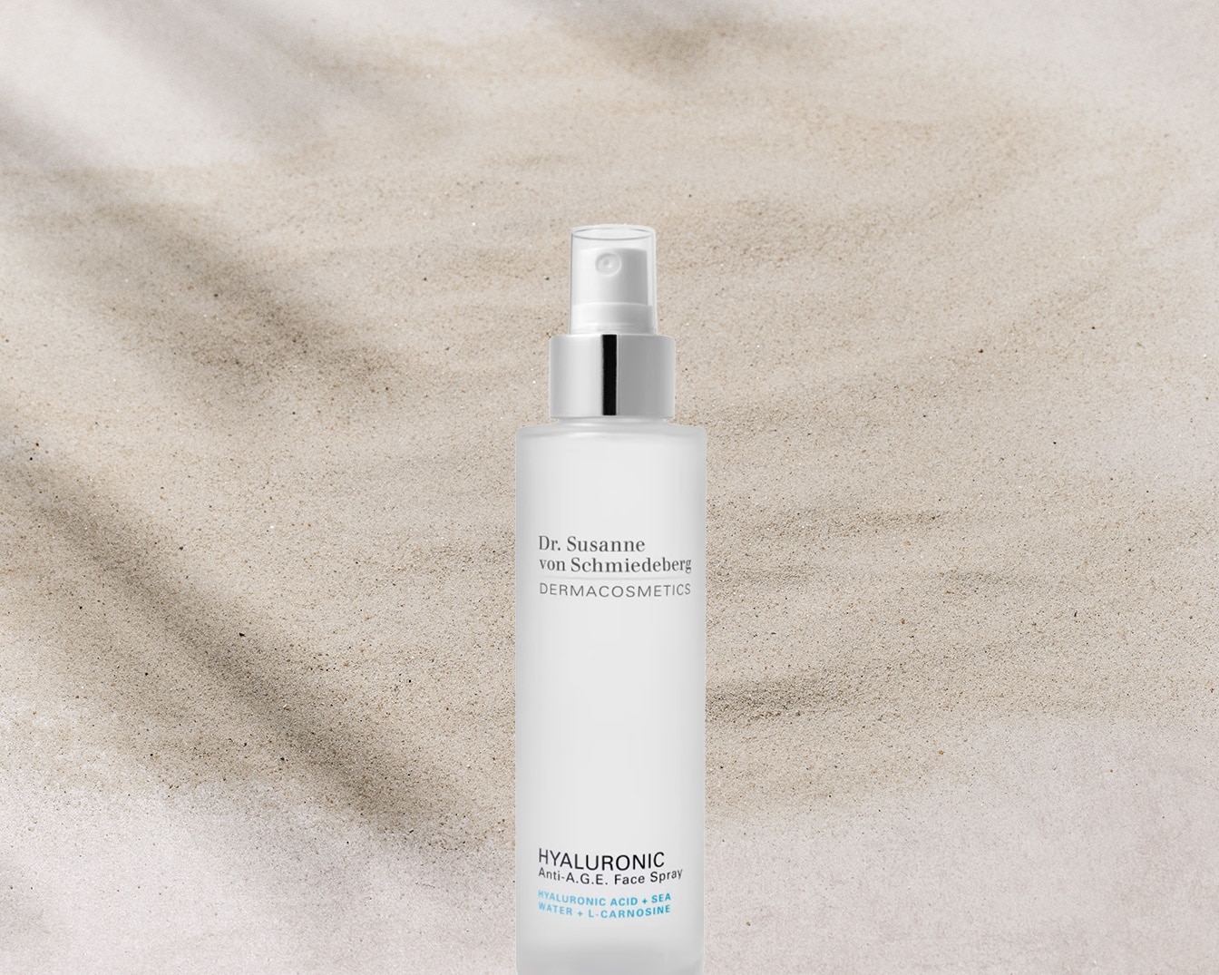 Ecco lo spray viso Hyaluronic Anti-A.G.E. di Dr. Susanne von Schmiedeberg DERMACOSMETICS, con acido ialuronico, acqua marina e L-carnosina, in una confezione bianca con erogatore spray.