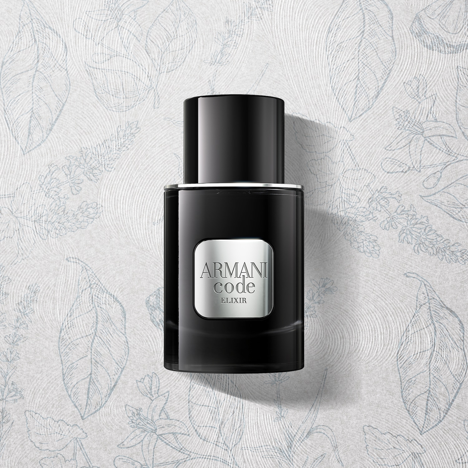 Czarna butelka Armani Code Elixir na tle z delikatnym wzorem roślinnym.
