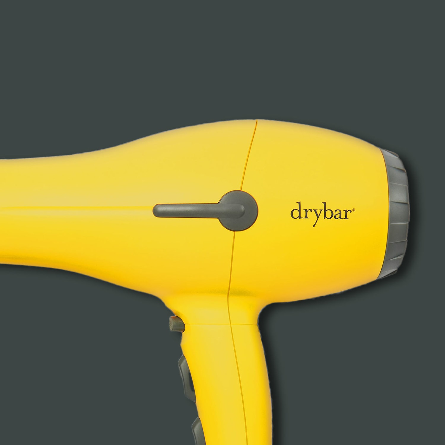 Sárga Drybar hajszárító fekete részletekkel és logóval, amely a hajformázás élénk és hatékony módját kínálja.